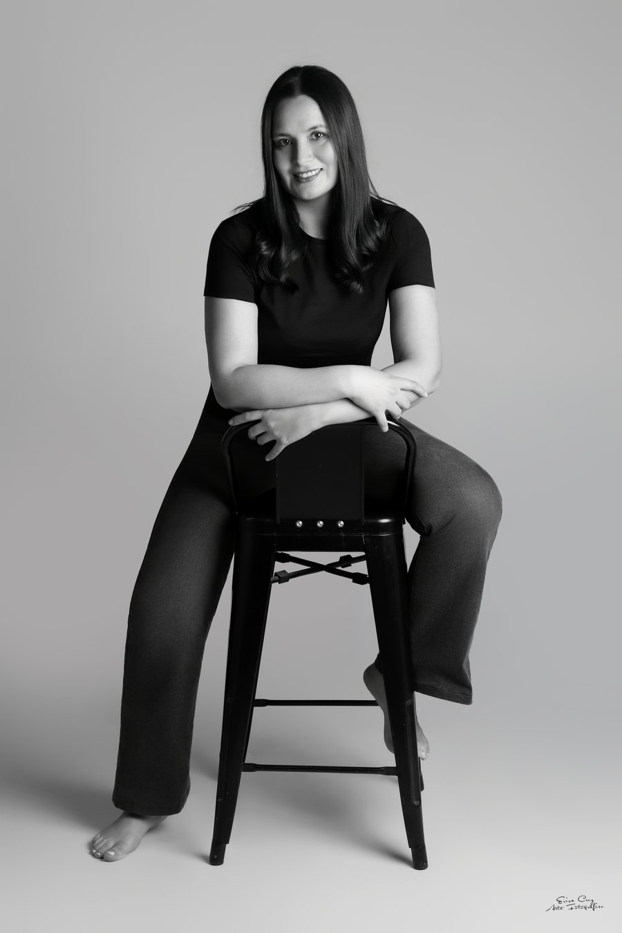 Retrato en blanco y negro de mujer sentada en banco de estudio, Erica Cruz