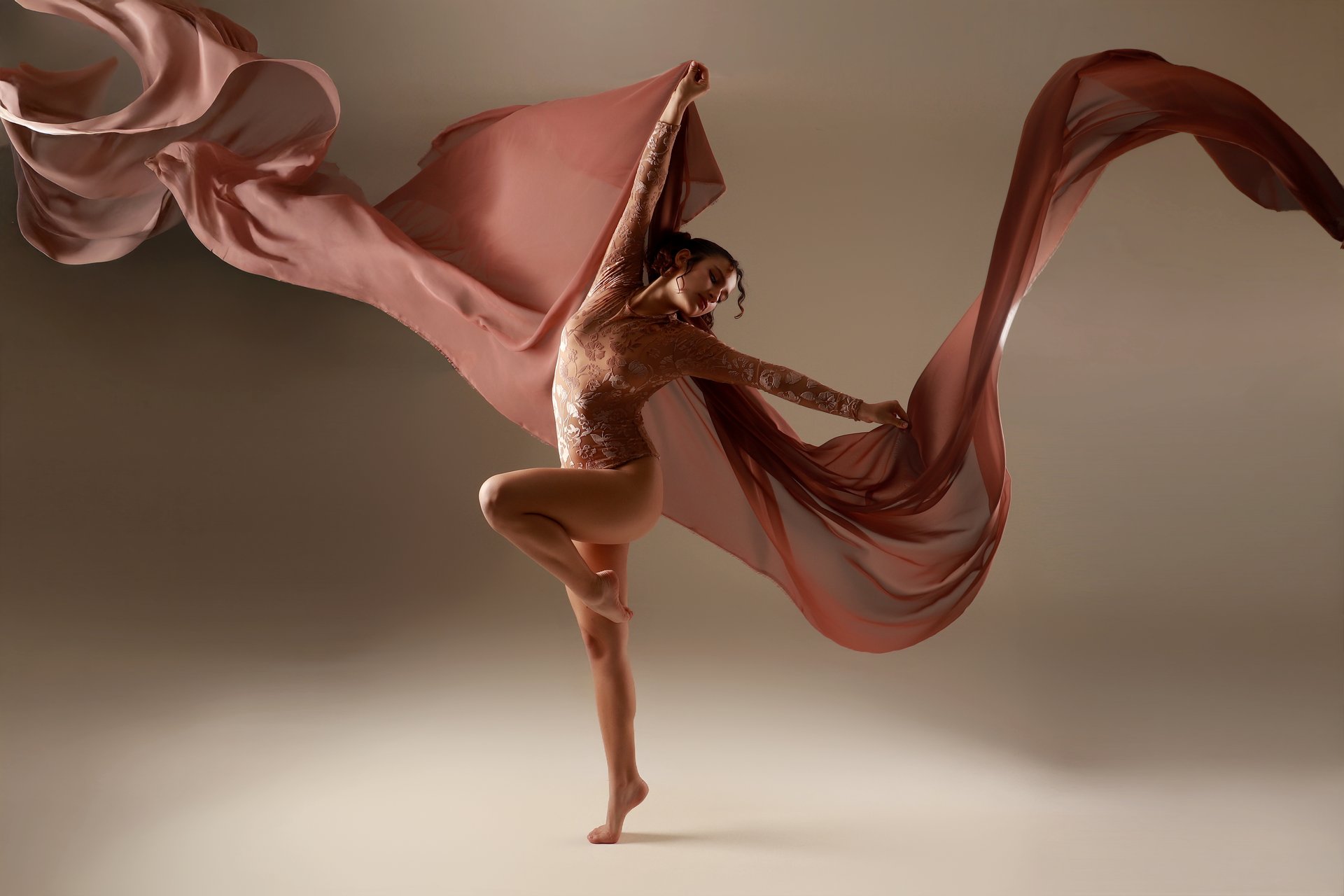 Bailarina en movimiento con tela coral extendida en el aire, sesión artística Erica Cruz