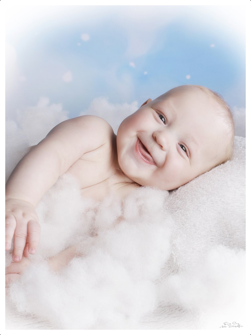 Bebé riendo entre nubes y cielo azul, Erica Cruz