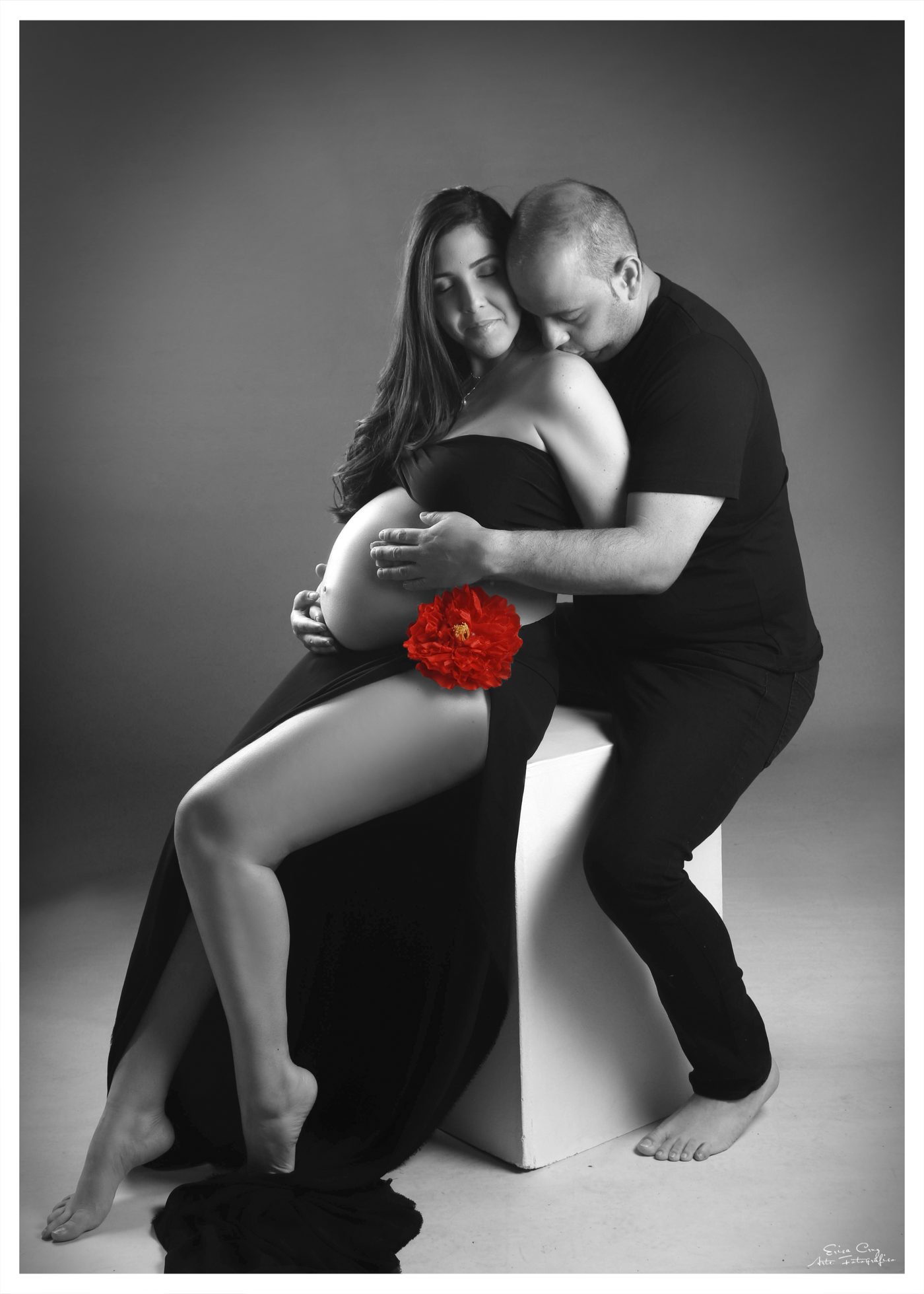 Pareja sentada abrazada junto a una flor roja, blanco y negro, Erica Cruz