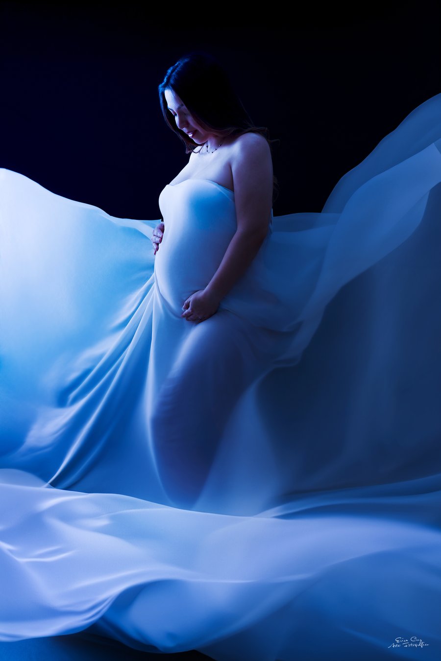 Embarazada con vestido azul en estudio oscuro, Erica Cruz