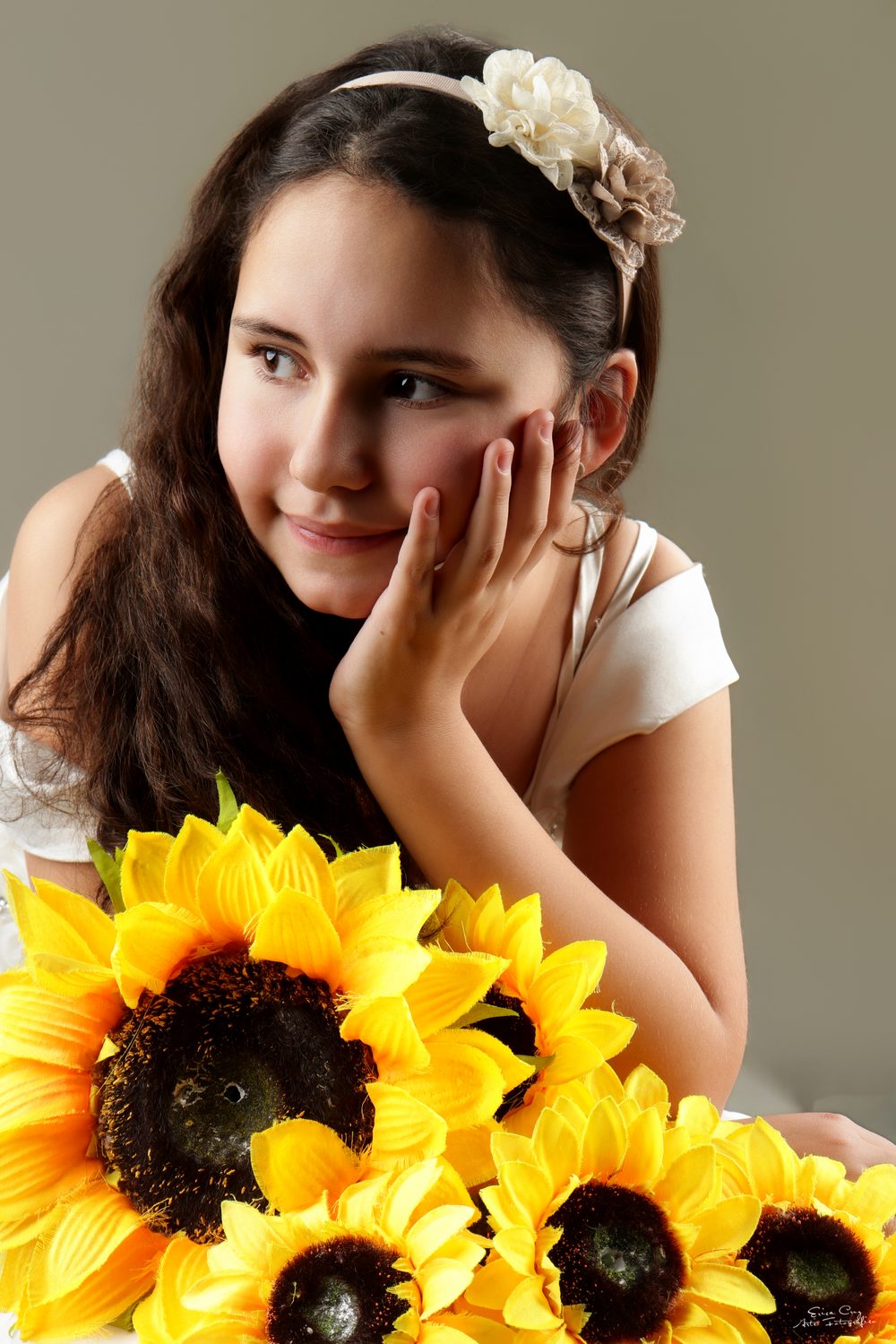 Niña con girasoles apoyando su mano en el rostro, Erica Cruz