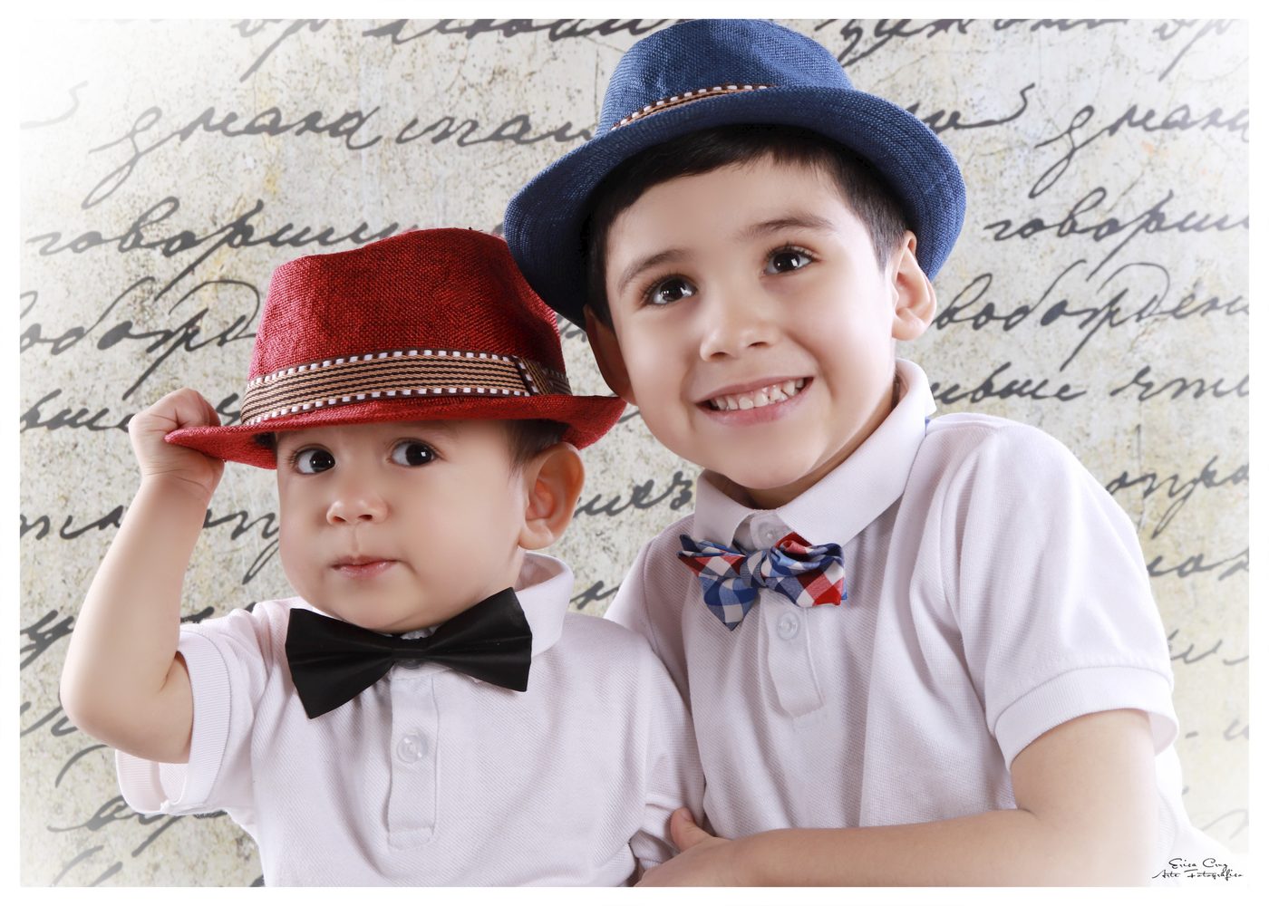 Dos hermanos con sombreros y moños de novedad, Erica Cruz