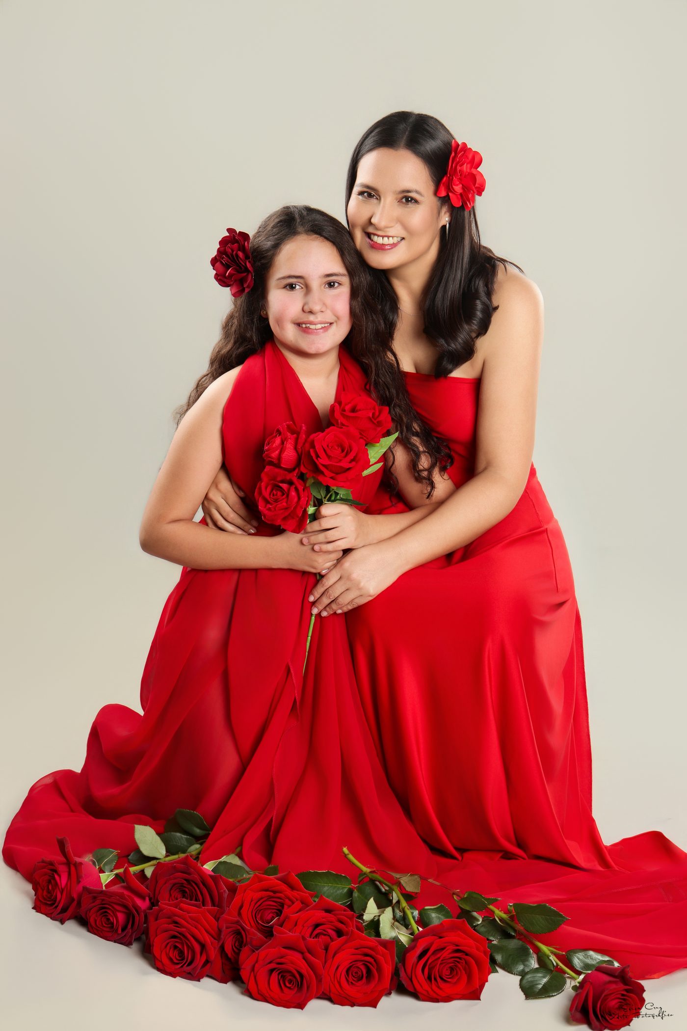 Madre e hija con vestidos rojos entre rosas, Erica Cruz