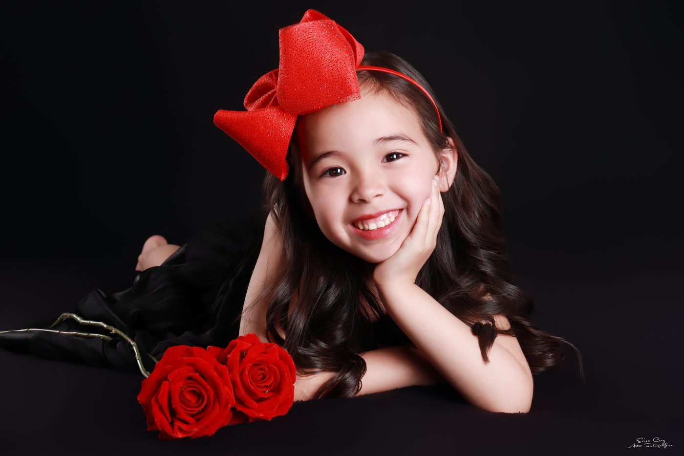Niña con moño rojo y rosas rojas, Erica Cruz