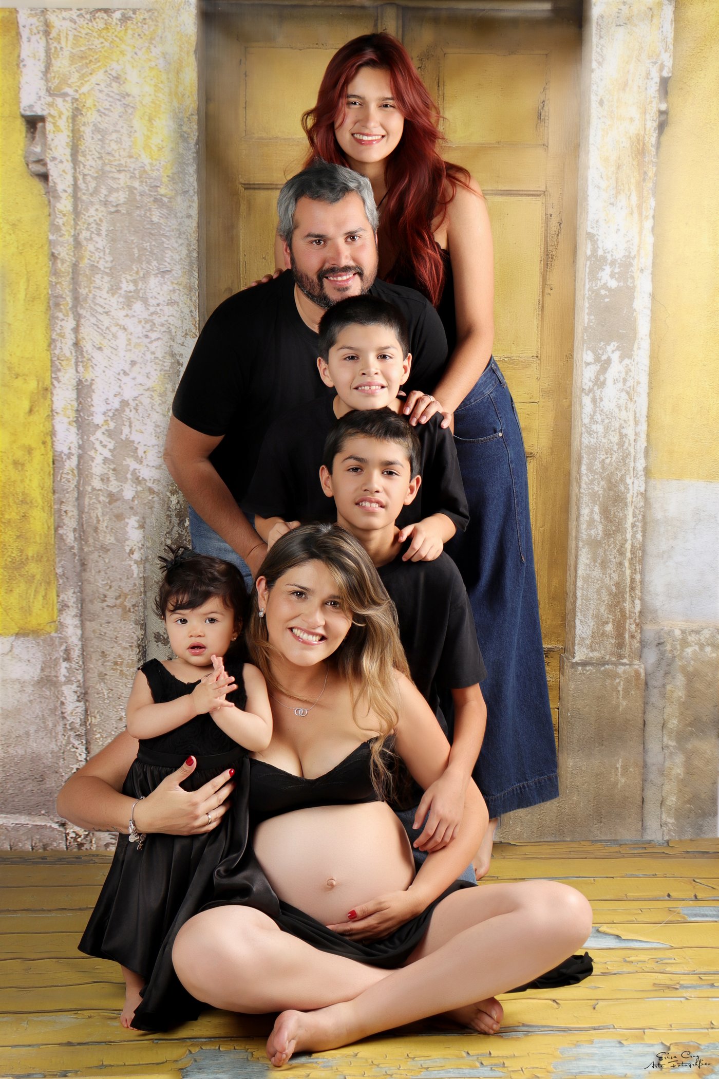 Familia frente a puerta rústica amarilla — ver sesiones Familiares, Erica Cruz